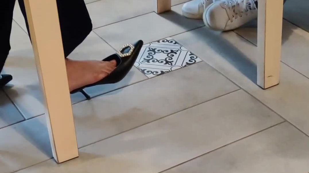 dipping black mules under table