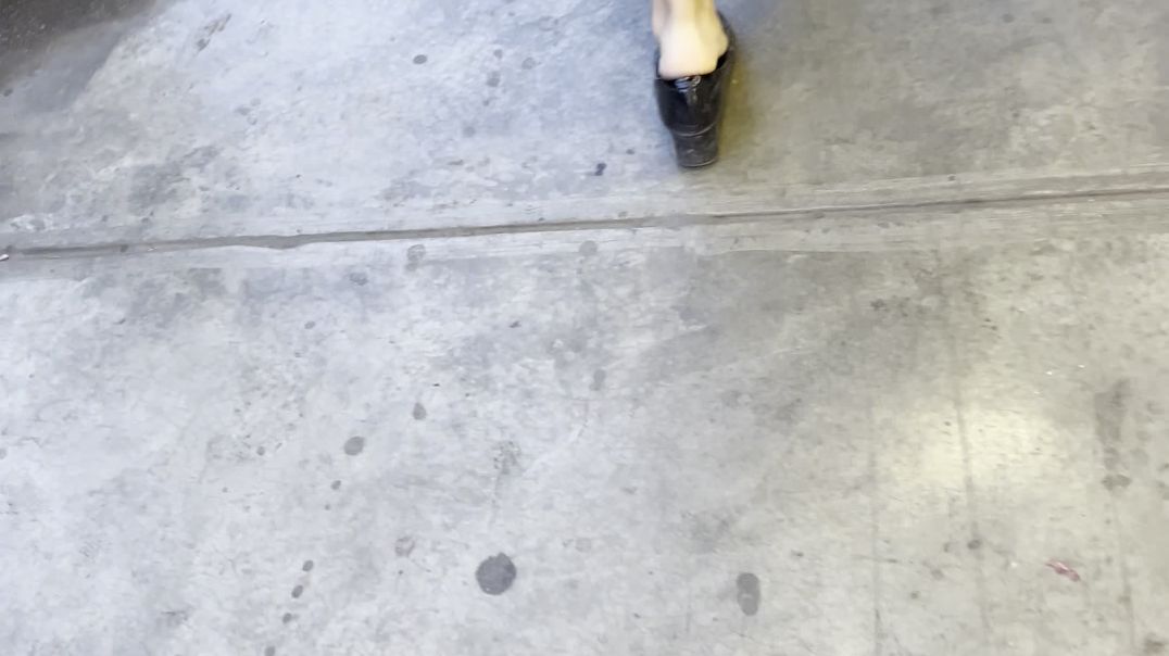 Woman walking with bigs and stretched heels.